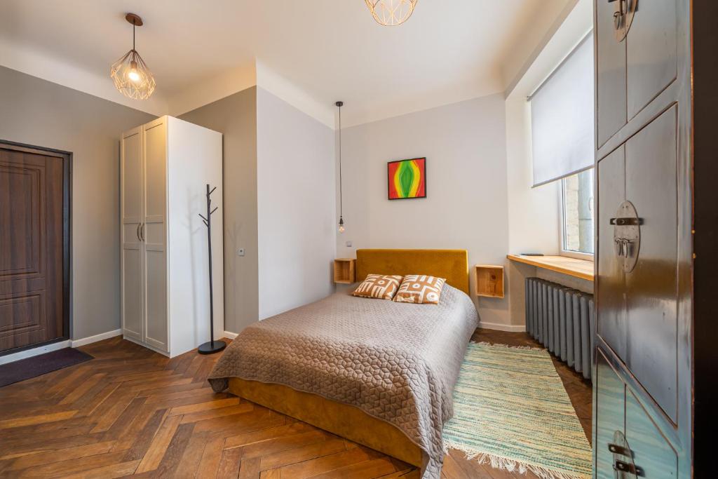 a small bedroom with a bed and a window at Baltic Design Apartments with free Parking in Riga