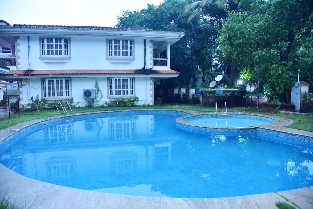 a swimming pool in front of a house at Good will villa in Varca