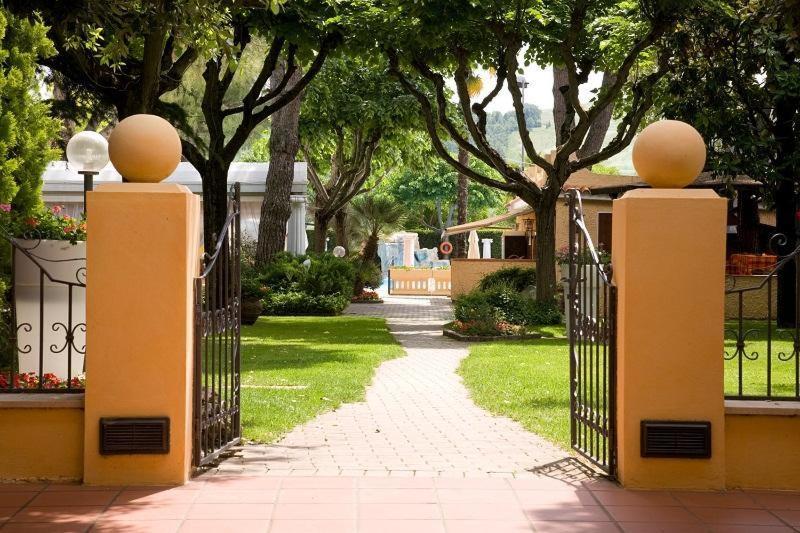 a gate to a driveway with trees and a house at Oscar e Amorina in Montegiorgio