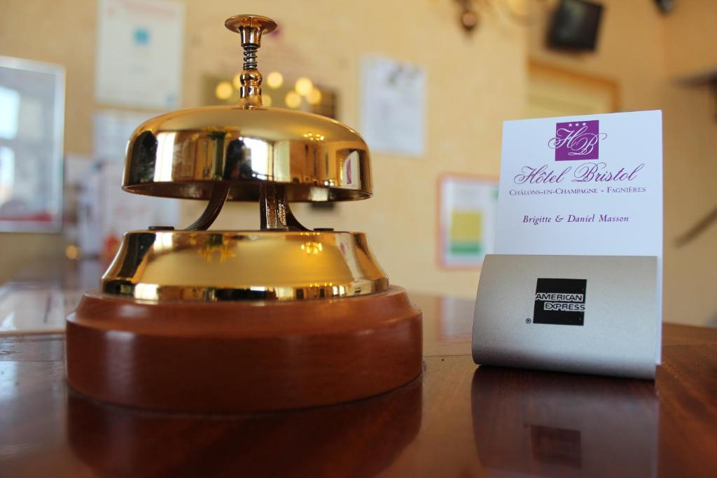 a bell sitting on a table next to a sign at Hotel Bristol in Chalons en Champagne