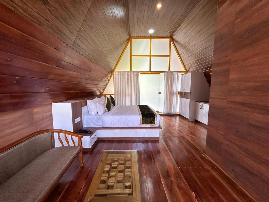 - une chambre avec un lit et un canapé dans l'établissement Suvarna Eco Village, à Madikeri