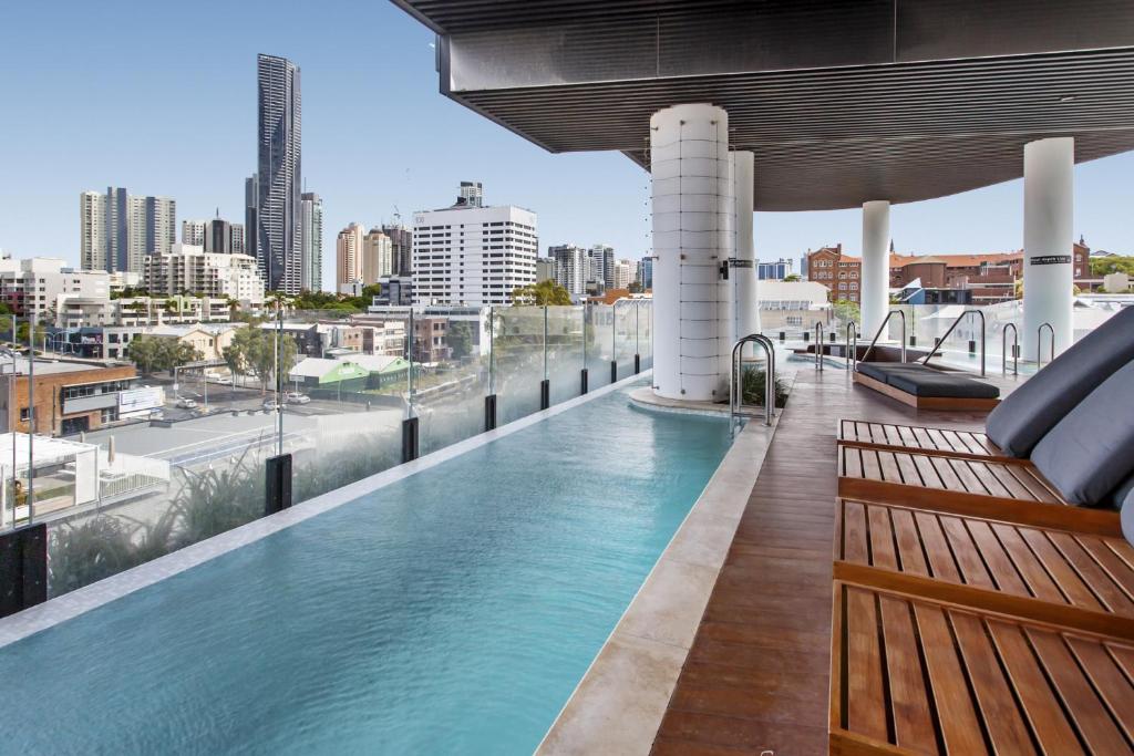 a swimming pool on the roof of a building with a city at Chic 1-Bed with Parking, Rooftop Pool and Gym in Brisbane