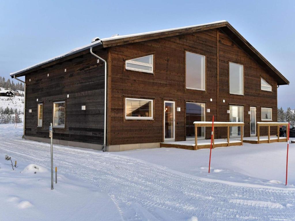 une maison en bois dans la neige recouverte de neige dans l'établissement 12 person holiday home in IDRE, à Idre