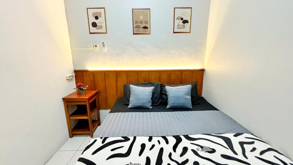 NgeKost harian في Alastuwo: غرفة نوم صغيرة مع سرير وموقف ليلي