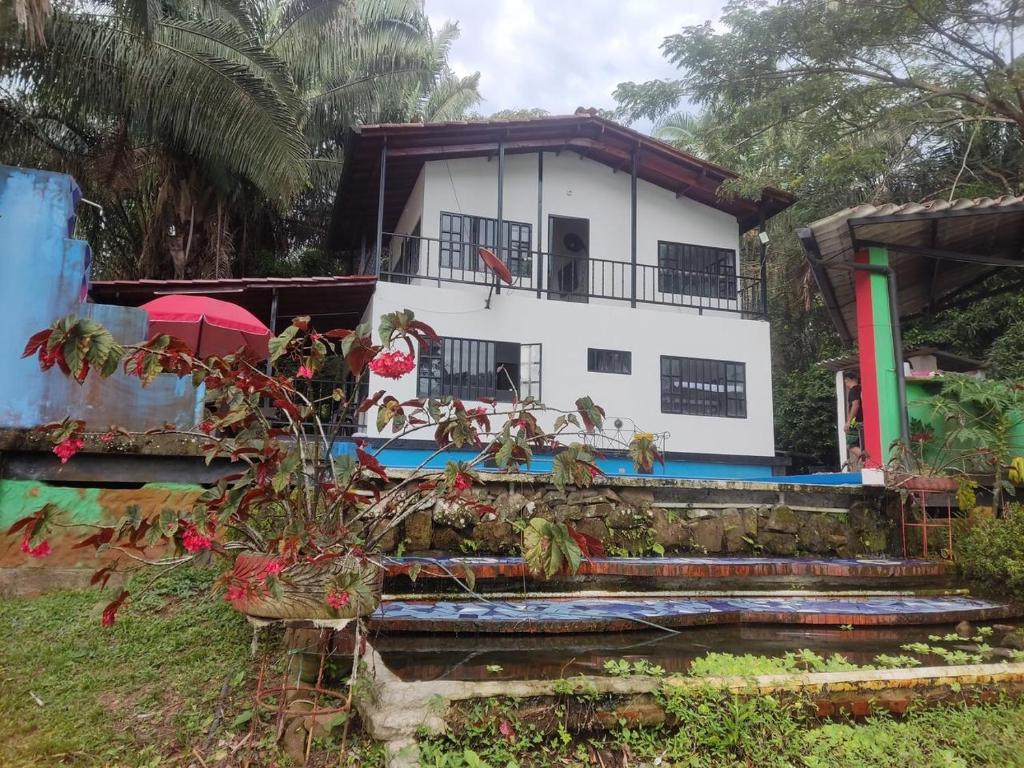 Casa blanca con balcón y algunas plantas en Quinta Prado Mar en Prado