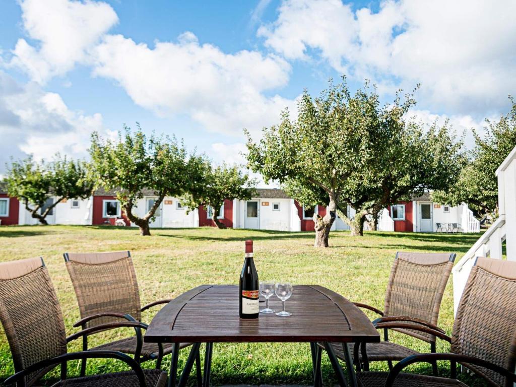 - une bouteille de vin assise sur une table avec des chaises dans l'établissement 6 person holiday home in Allinge, à Allinge