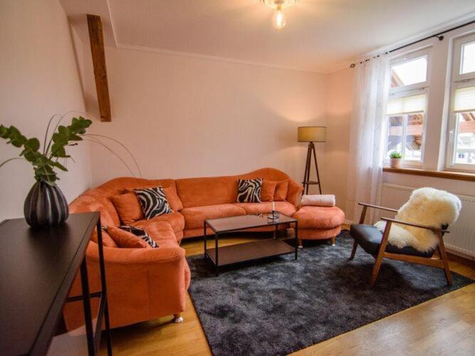 a living room with an orange couch and chairs at WERTS HOF Apartment 2 