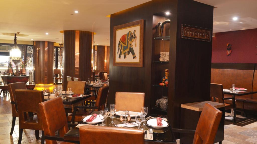 كراون بلازا كويت الثريا سيتي في الكويت: مطعم فيه طاولات وكراسي في الغرفة