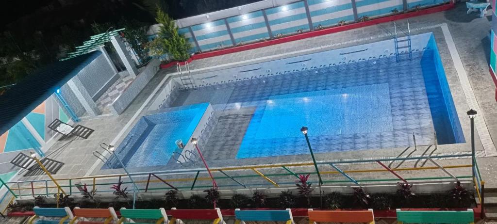 a large swimming pool with chairs in front of it at HSV WONDER WORLD,FARM HOUSES in Venkatāpur