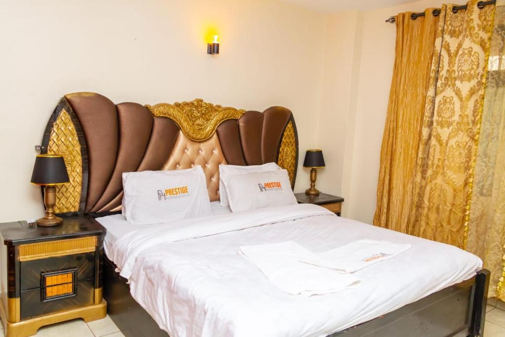 una camera da letto con un grande letto con lenzuola bianche di Enk apartments a Nairobi