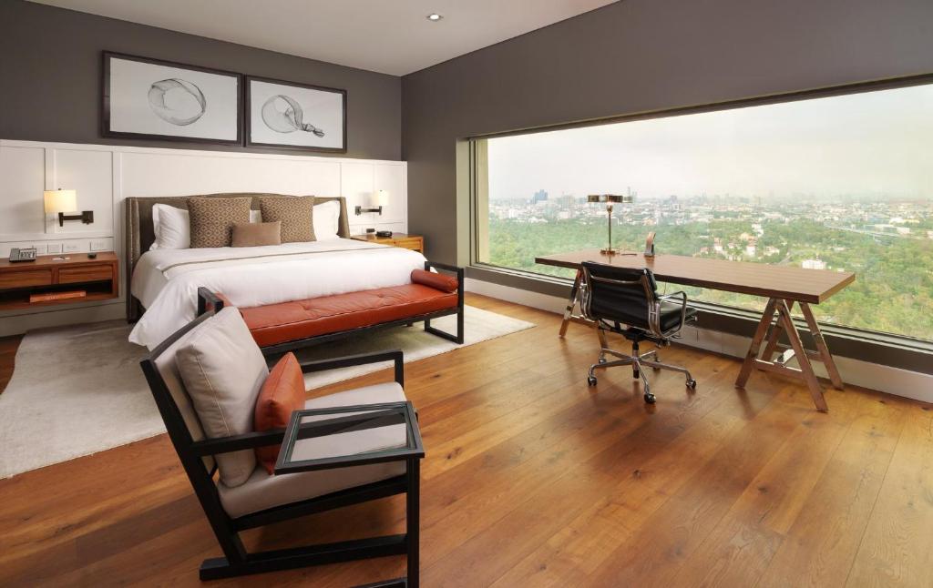 A bright bedroom with a large picture window and a dedicated desk.