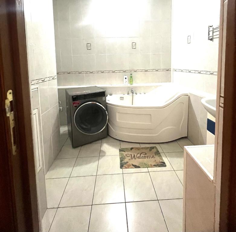 een badkamer met een wasmachine en een wastafel bij 458 Рядом Байтерек с кондиционером 2 большими кроватями и раскладным диваном для компании 1-6 человек in Astana