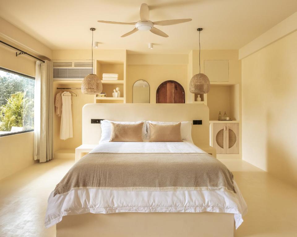 a bedroom with a bed and a ceiling fan at Isla Retreat in Fehendhoo