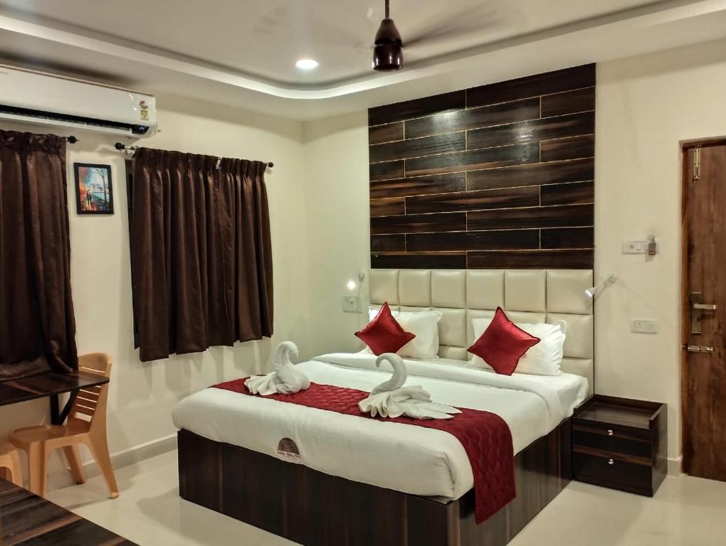 um quarto com uma cama grande e almofadas vermelhas em ANNAI RESIDENCY em Vellore