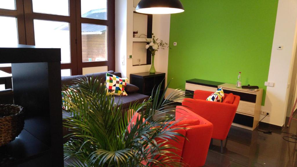ein Wohnzimmer mit grünen Wänden und roten Stühlen in der Unterkunft Apartment Rhein Main in Hochheim am Main