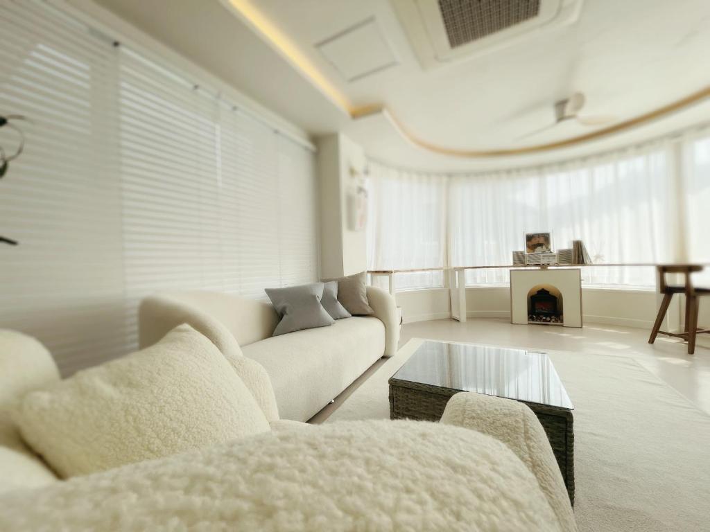 a living room with white furniture and a fireplace at Gapyeong B481 in Gapyeong