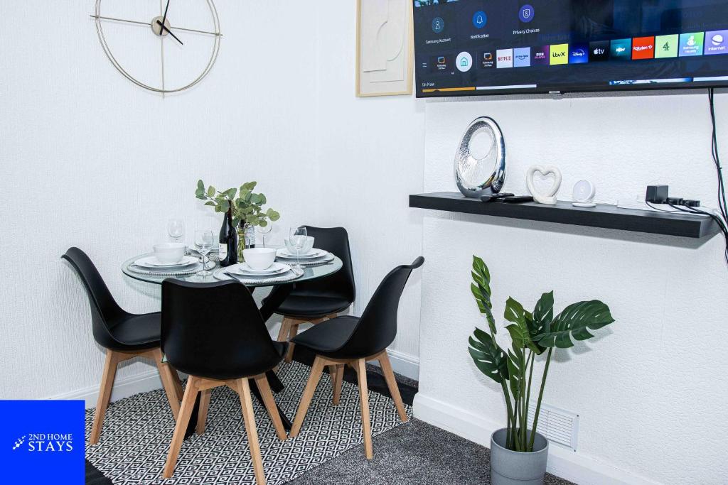 a dining room with a table and four chairs at 2ndHomeStays-3 Bedroom House - Sleeps 6 - City Centre -Stoke-on-Trent in Stoke on Trent