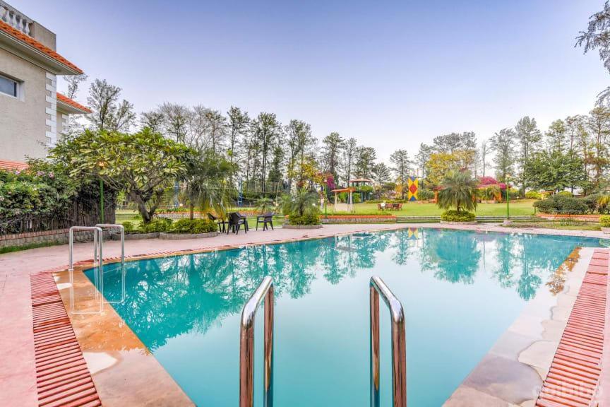 uma piscina com água azul num parque em Green Orchid Farms I Swimming Pool I Wedding I party I 87oo2o5865 em Gurgaon