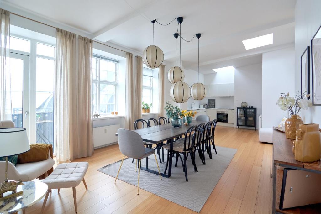 una sala da pranzo e un soggiorno con tavolo e sedie. di Penthouse-Nordic-Citycenter-Balcony a Copenaghen