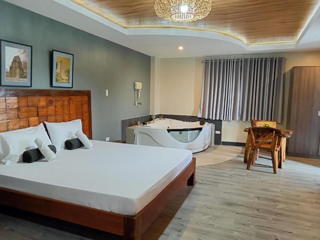 een slaapkamer met een groot bed en een bad bij Norlu Cedec Midpoint Hotel in Rosario