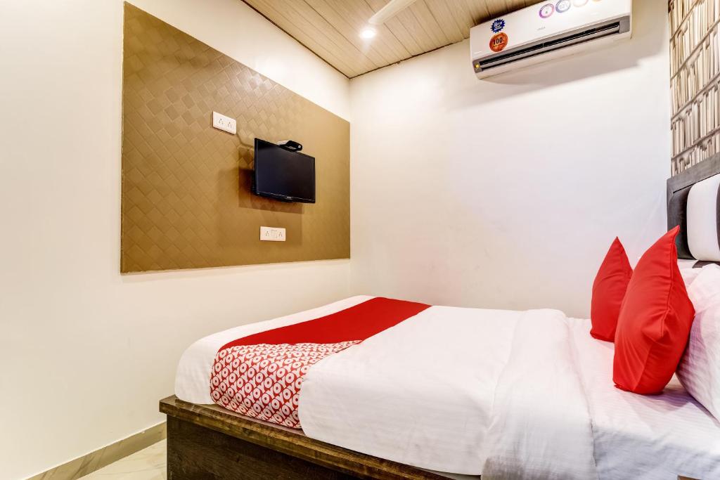 1 dormitorio con 1 cama y TV en la pared en OYO Flagship Hotel Qubic, en Bombay