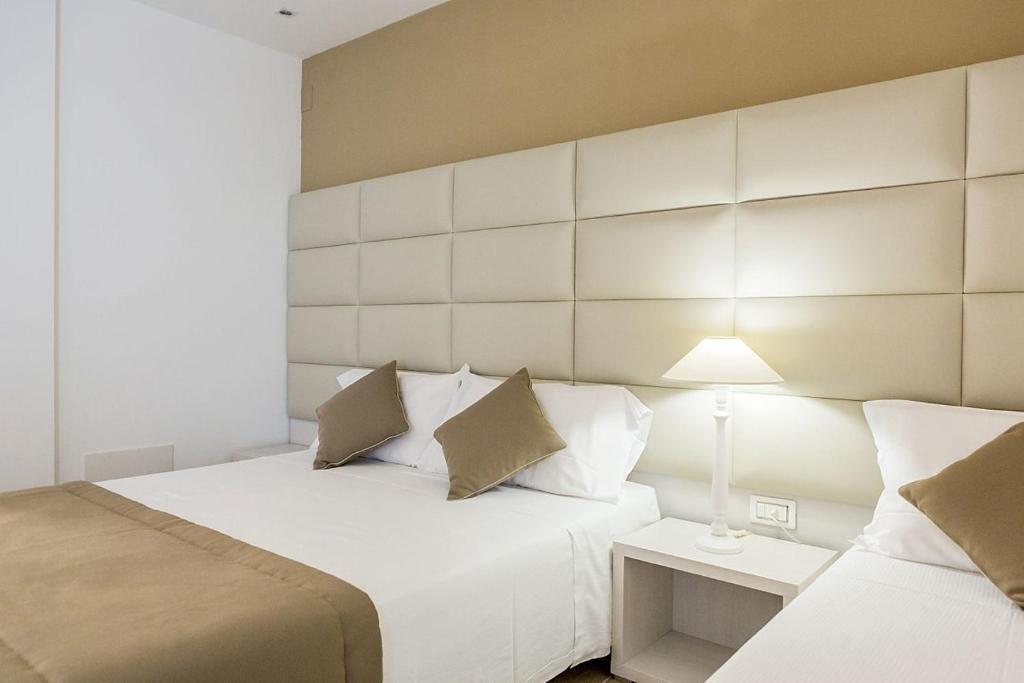 una habitación de hotel con 2 camas y una lámpara en Hotel Vittoria, en Vasto