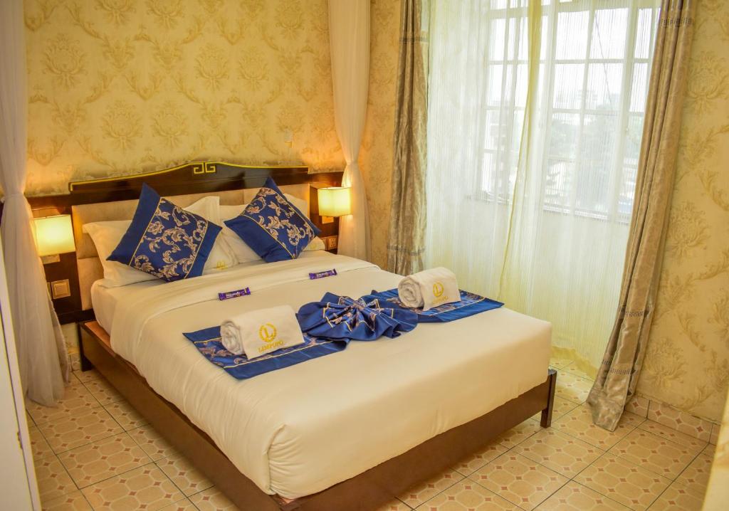een slaapkamer met een bed met blauwe en witte kussens bij Limpopo Suites in Nairobi