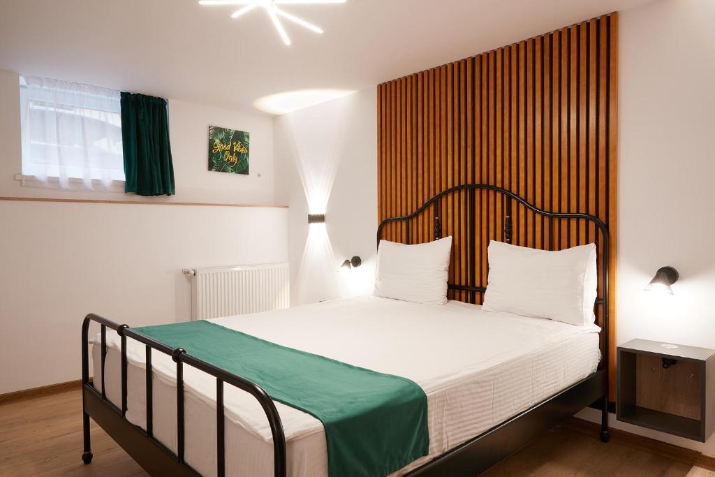 una camera con letto e testiera in legno di Giovi Central Apartment a Cluj-Napoca