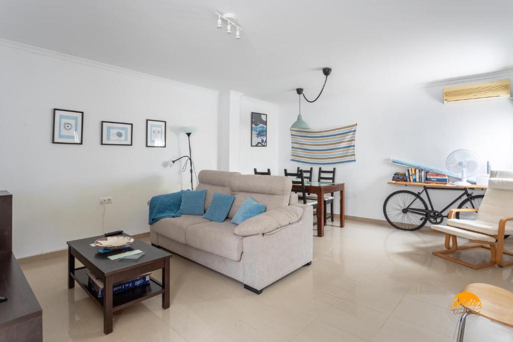 ein Wohnzimmer mit einem Sofa und einem Tisch in der Unterkunft Apartamento Lavandula by Cadiz Time in Cádiz