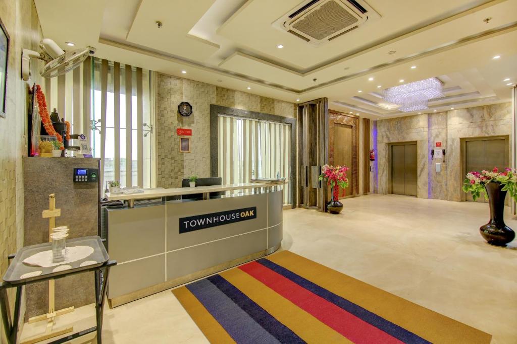 un vestíbulo de un edificio con una cruz en una alfombra colorida en Super Townhouse OAK Hotel C Pearls, en Nueva Delhi