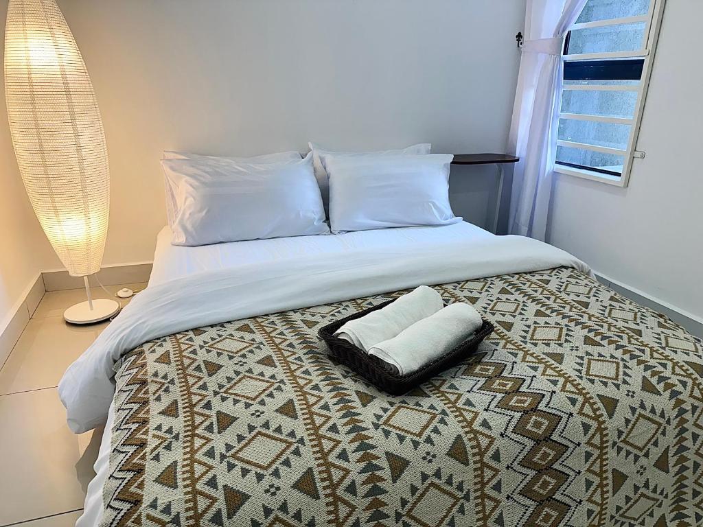 a bedroom with a bed with a pillow on it at The Borneo Suite - Group of 6 - 9 pax in Kota Kinabalu