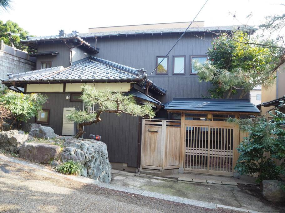 una casa con un cancello in legno di fronte di Holiday Villa ボストン a Niigata
