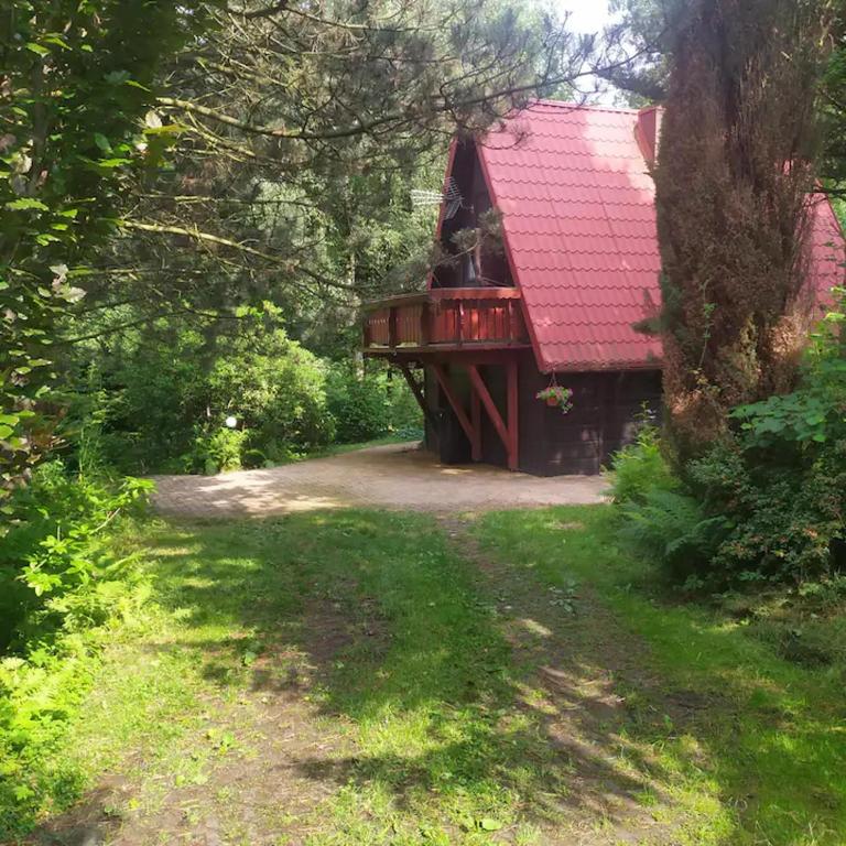 a house with a red roof in the woods at Cottage in the picturesque Beskid Maly Mountains in Porąbka
