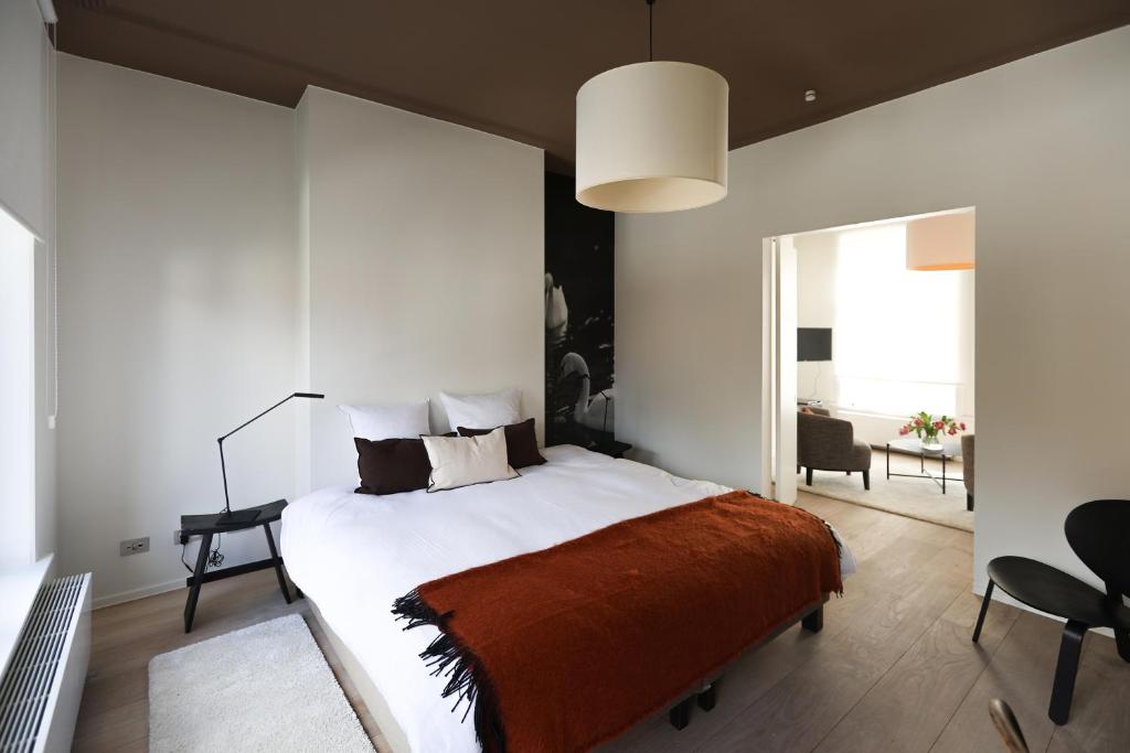 a bedroom with a large bed with a orange blanket at Residence9Bruges in Bruges