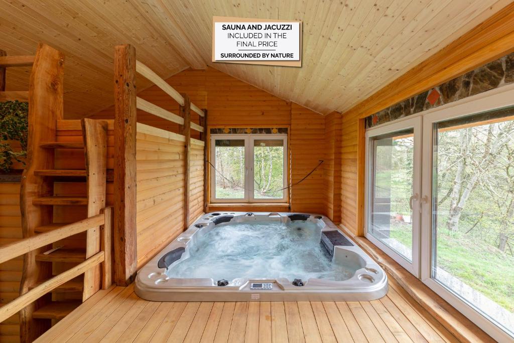 una sauna con bañera de hidromasaje en una sala de madera en Goričko Relax House, en Kuzma