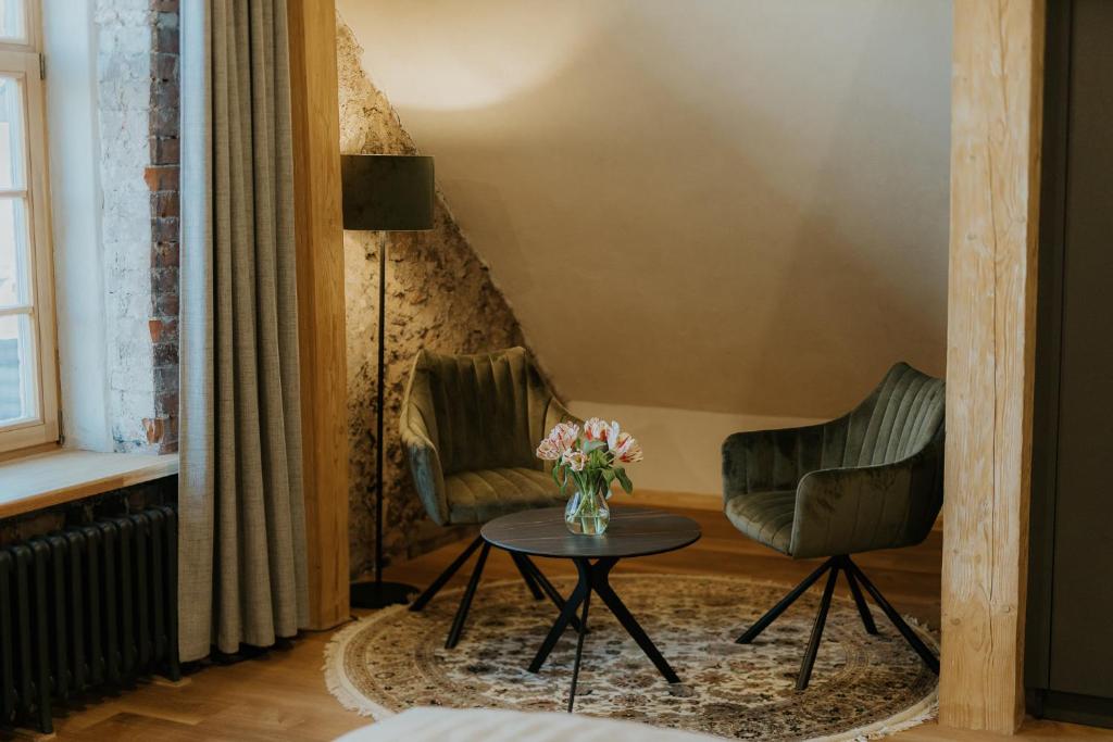 uma sala de estar com duas cadeiras e uma mesa em Zīles - Atpūtas komplekss em Jēkabpils