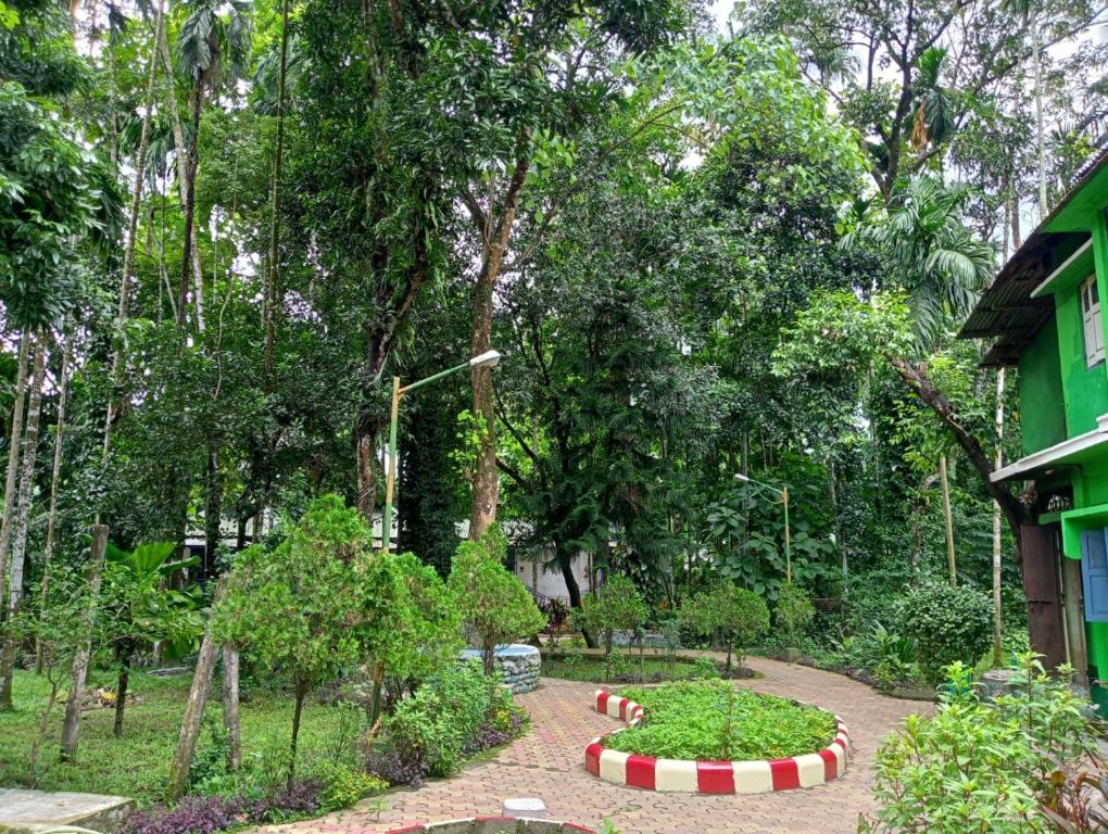 un jardín con un círculo de plantas y árboles en Sylvan Retreats, en Lataguri