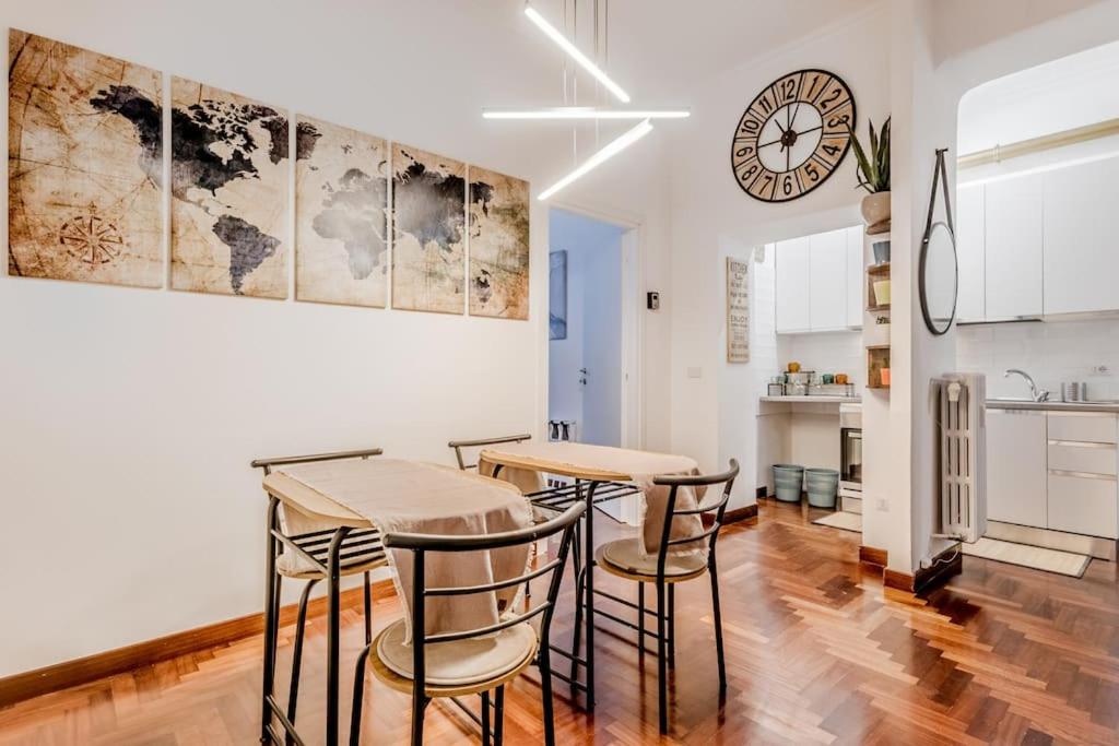 une cuisine avec une table, des chaises et une horloge dans l'établissement Holiday Home i Cervi, à Rome