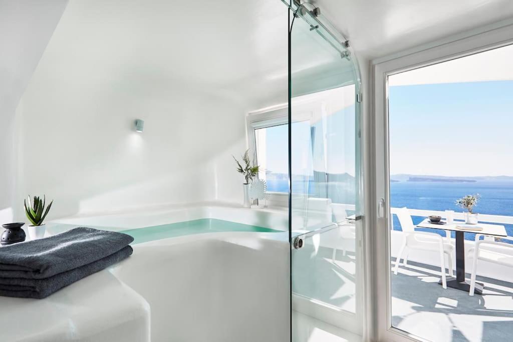 ein weißes Bad mit einer Dusche und einer Glastür in der Unterkunft DAY DREAM 1 in Oia
