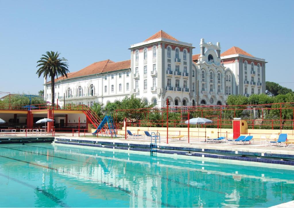 uma piscina em frente a um grande edifício em Curia Palace Hotel & Spa em Curia