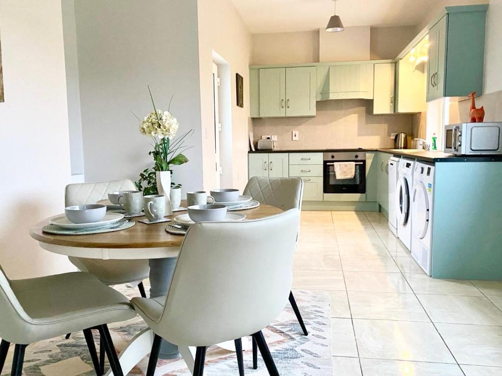 a kitchen with a wooden table and white chairs at Pine View In The Heart Of The West in Lisacul