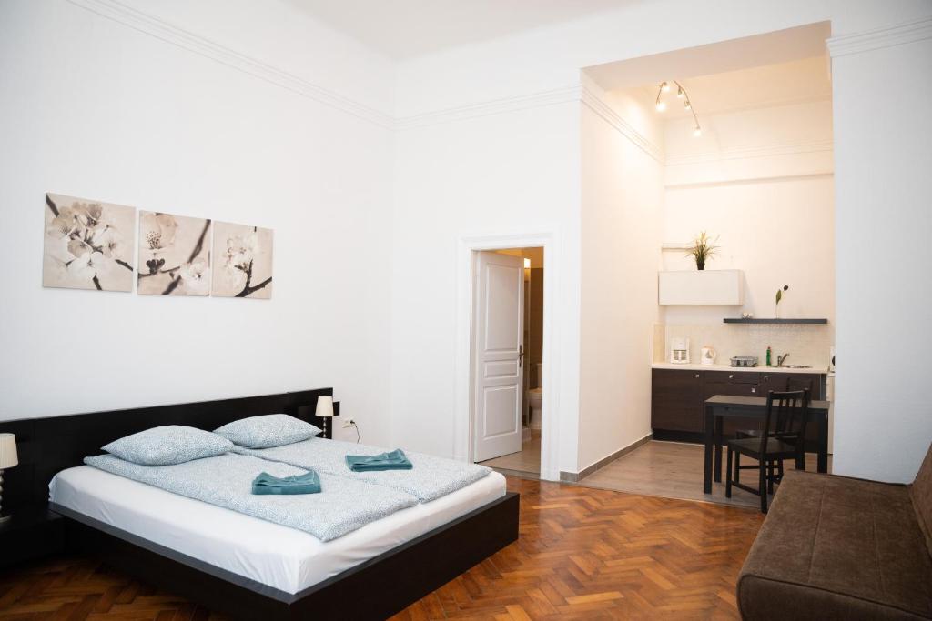 a bedroom with a bed and a dining room at Daphne Deluxe Apartment in Budapest