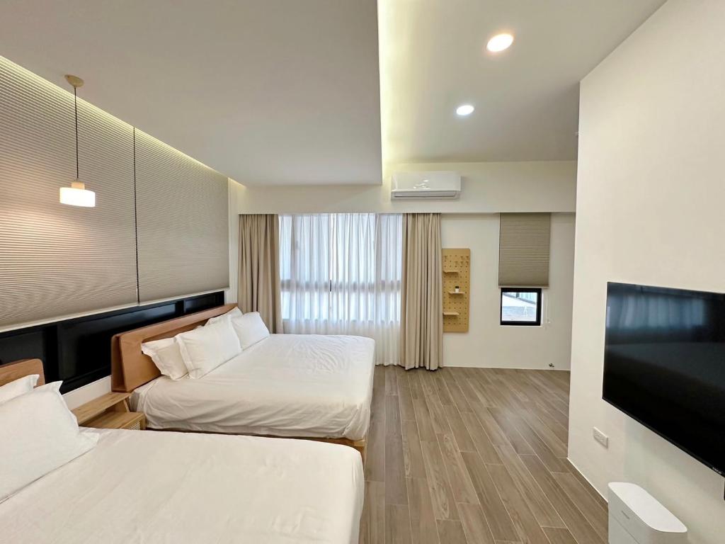 een hotelkamer met 2 bedden en een flatscreen-tv bij Salt&Light Inn in Magong