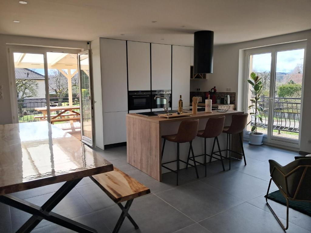 une cuisine avec un îlot et des tabourets de bar dans l'établissement Grand gîte des pins, à Chaumousey