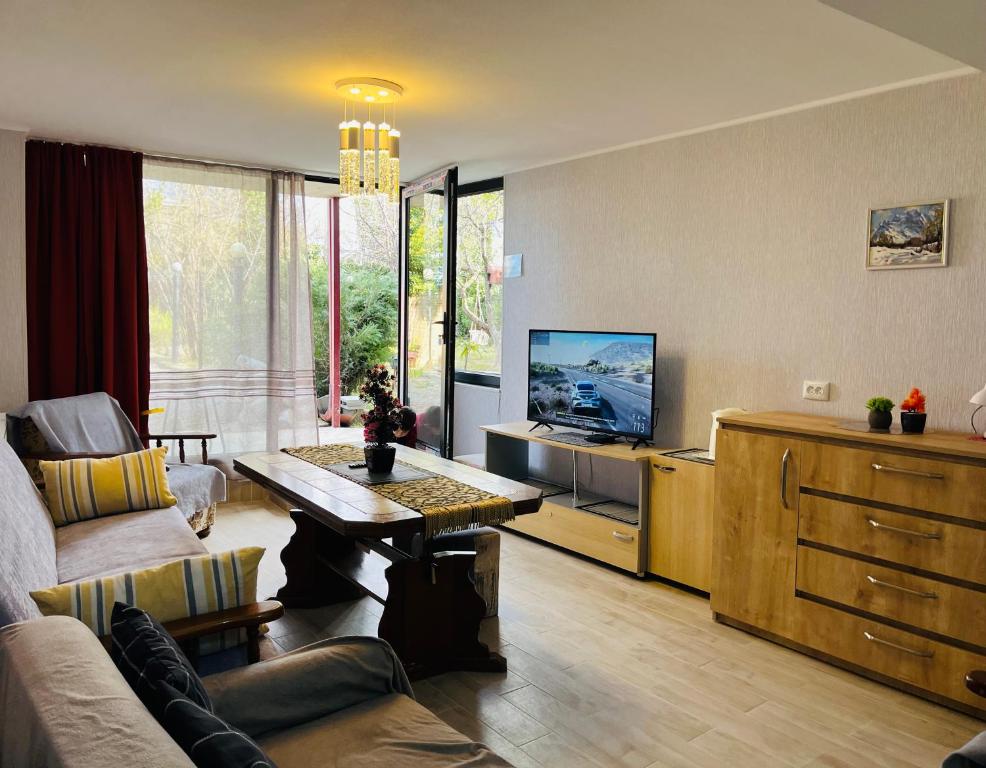 a living room with a couch and a tv at Guest house poligloti in Tʼelavi