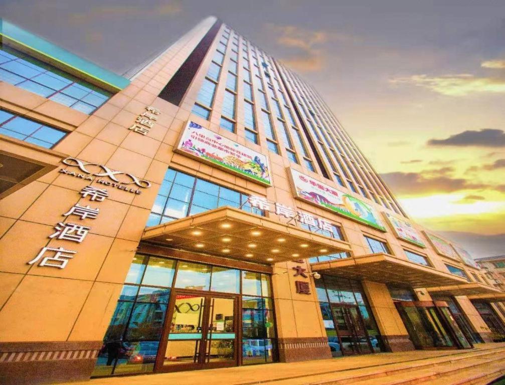 een hoog gebouw met veel ramen bij Xana Hotelle Tianjin Jingang Road Huaxi Branch in Jinnanqu