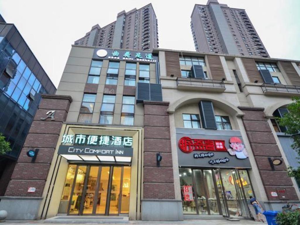 Jiang'anにあるCity Comfort Inn Wuhan Yuanlin Road Metro Stationの高い建物の前に店舗が並ぶ高い建物