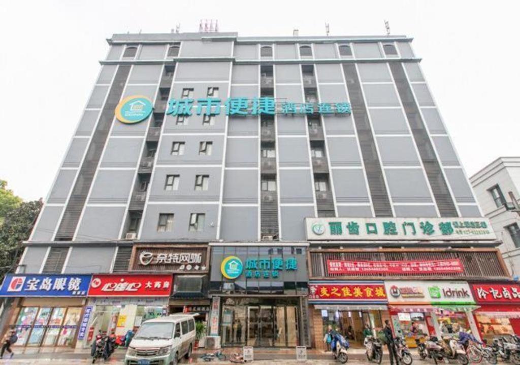 um grande edifício numa rua da cidade com pessoas em City Comfort Inn Wuhan Jiefang Avenue Xinrong Light Rail Station em Jiang'an