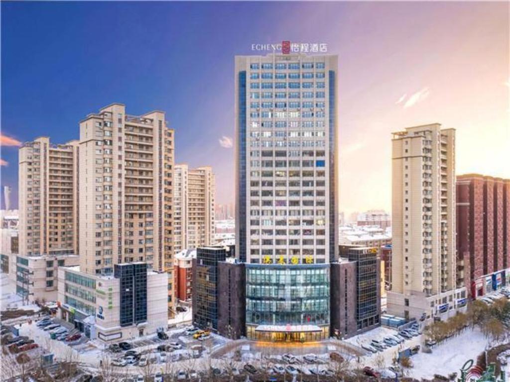 un edificio alto en una ciudad con edificios altos en E-Cheng Hotel Changchun Yiqi West High-Speed Railway Station, en Changchún