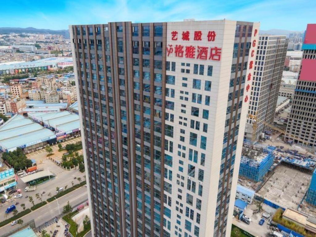 ein hohes Gebäude mit Schreiben auf der Seite in der Unterkunft Gya Hotel Kunming Zijin Center Xiaodongcun Metro Station in Kunming